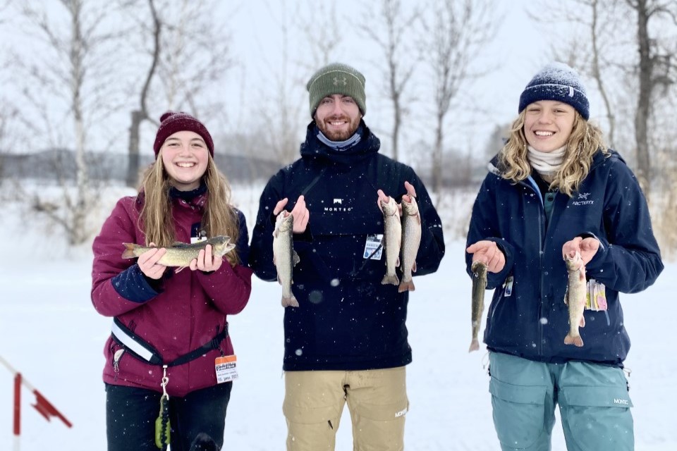 Pêche blanche Trois personnes avec les poissons qu'elles ont pêché pendant une partie de pêche blanche